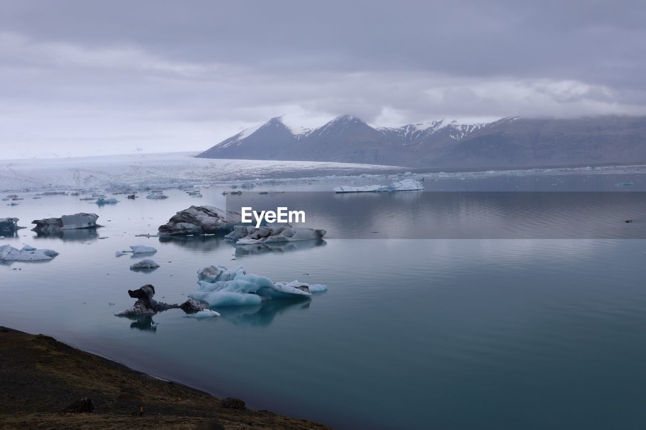 SCENIC VIEW OF SEA AND MOUNTAINS AGAINST SKY