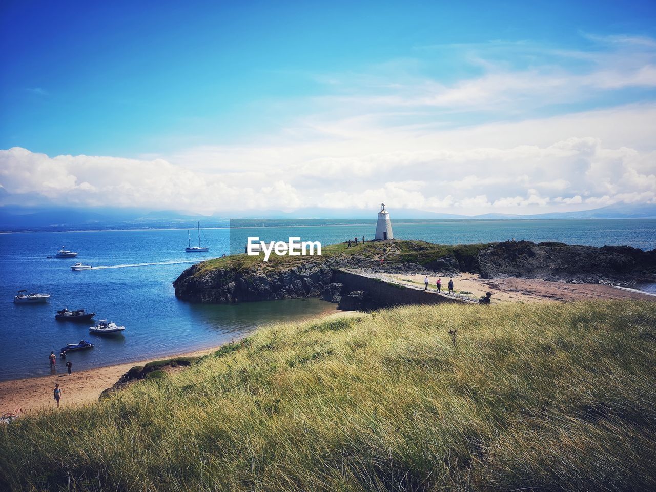 water, sea, sky, horizon, lighthouse, coast, land, beach, ocean, nature, shore, tower, architecture, cloud, scenics - nature, travel destinations, travel, built structure, beauty in nature, coastline, building exterior, guidance, blue, no people, building, cliff, nautical vessel, tourism, horizon over water, grass, day, transportation, plant, bay, reflection, landscape, tranquility, body of water, outdoors, environment, history, tranquil scene, terrain, the past, holiday, trip, vacation, cove, island, dusk, non-urban scene, summer, idyllic