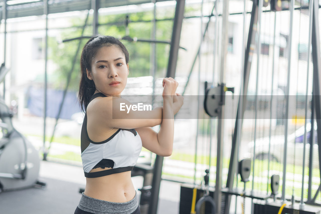 Portrait of young woman exercising at gym