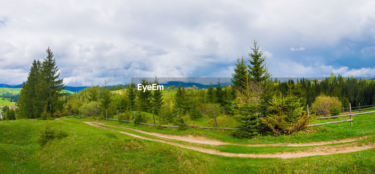 Picturesque spring carpathians panoramic scene with wooden split rail fence