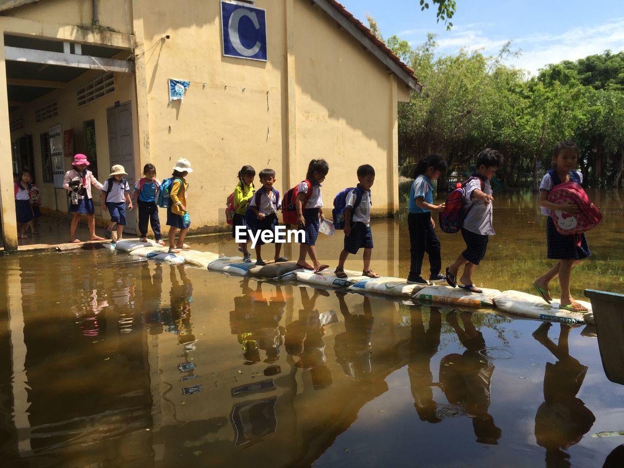 GROUP OF PEOPLE ON WET BUILDING