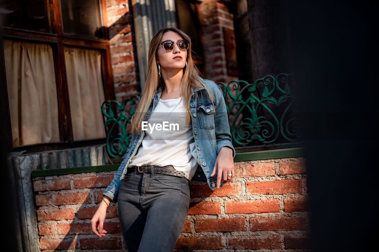 Young woman wearing casual clothing on the street. beautiful blond hair woman posing on the street.