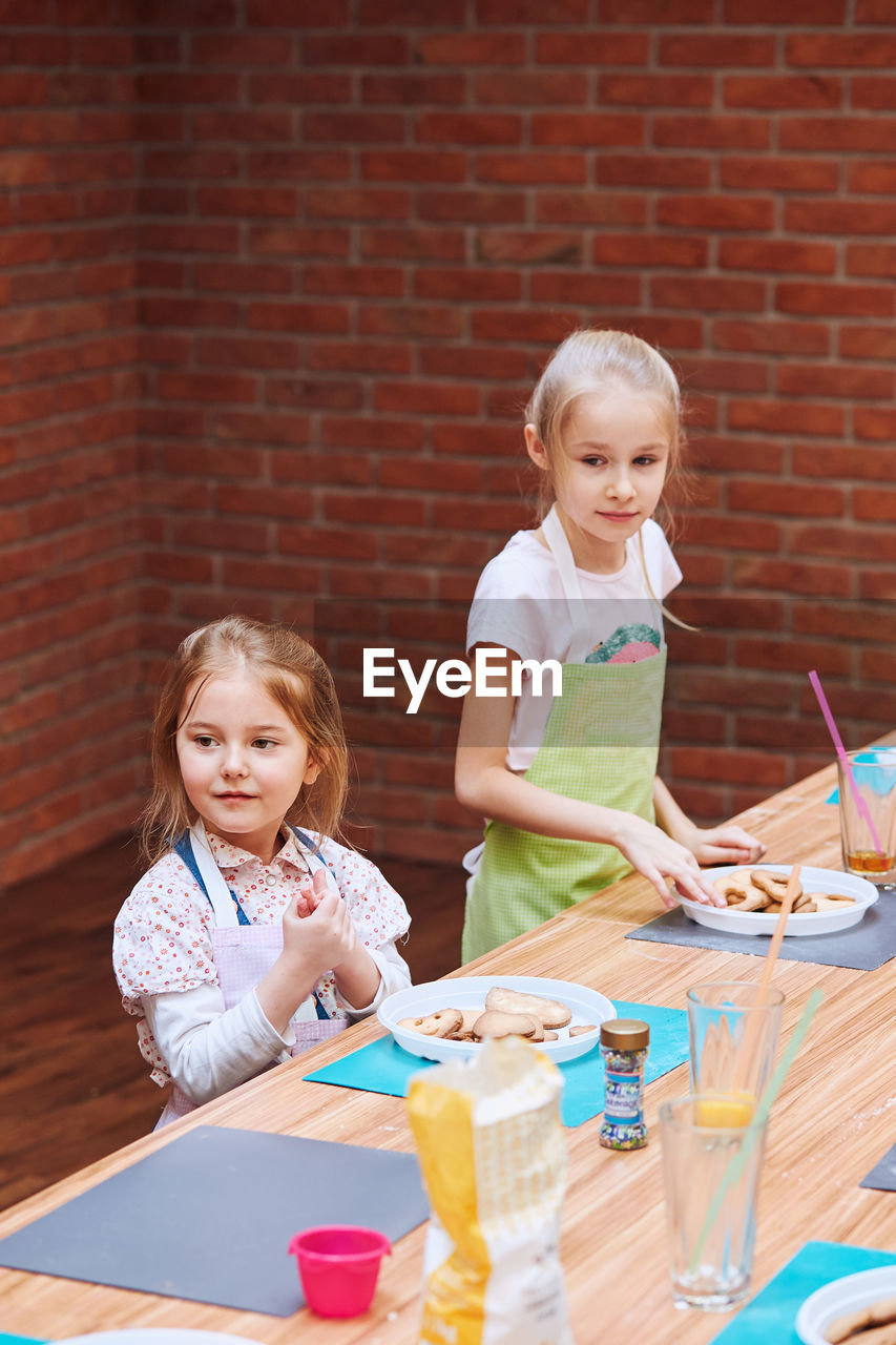 PORTRAIT OF A SMILING GIRL STANDING ON TABLE