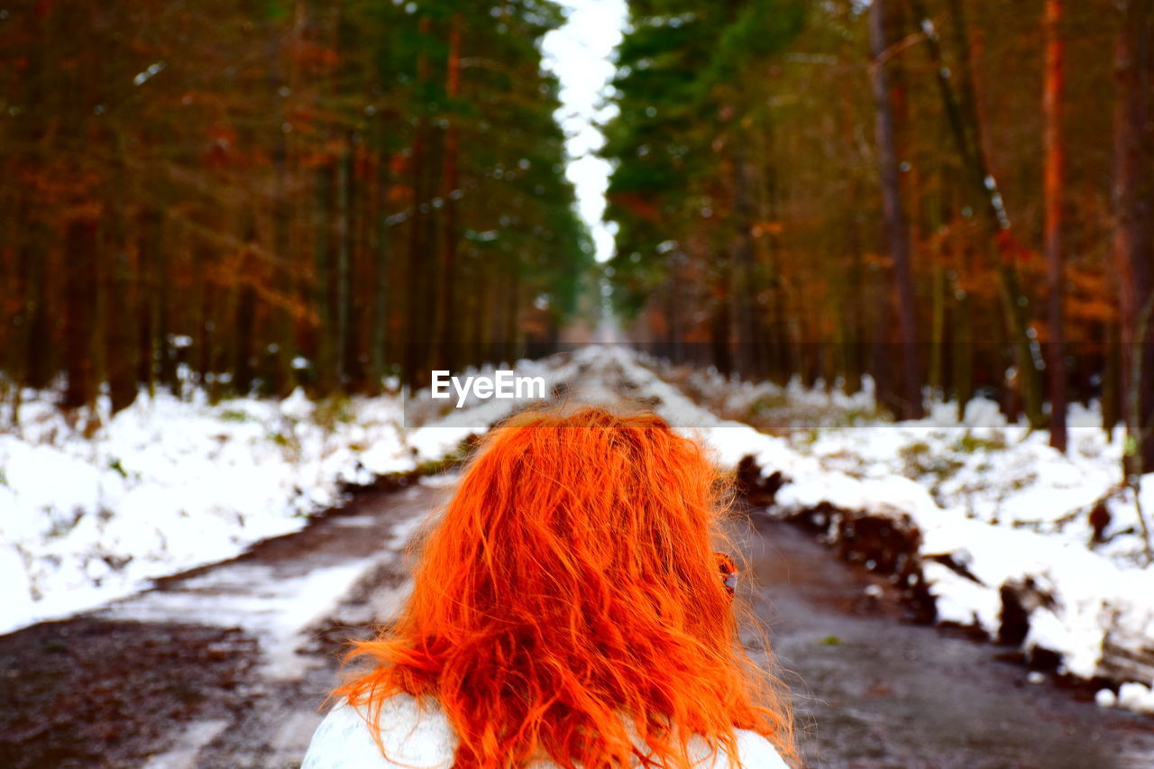 Rear view of redhead woman on road during winter