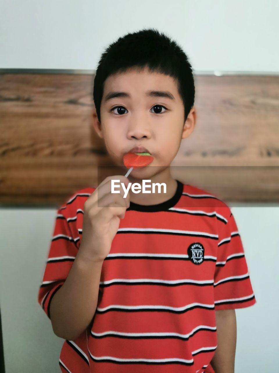 Portrait of cute boy eating candy