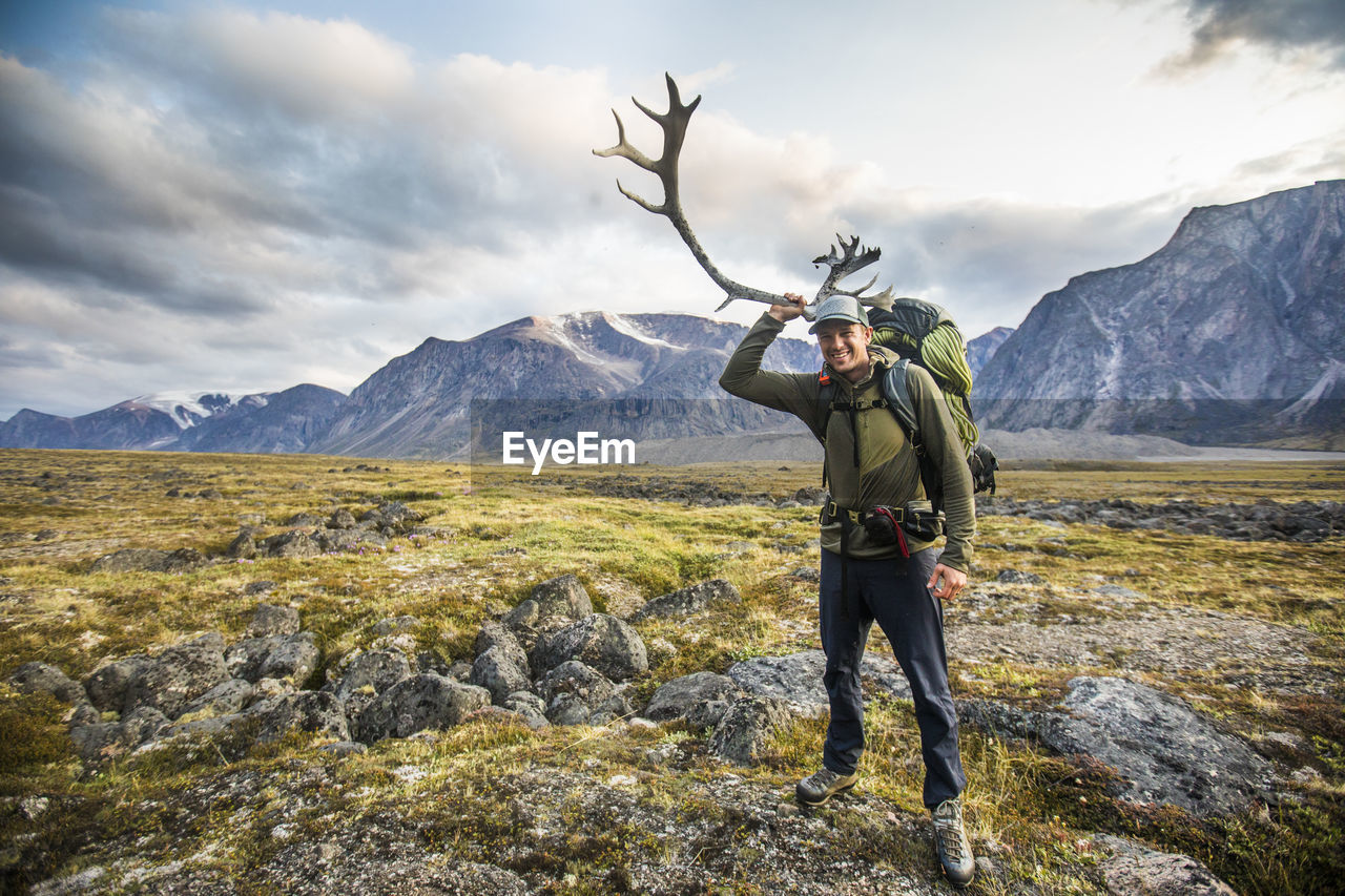 Backpacker holds caribou antler in auyuittuq national park, canada.