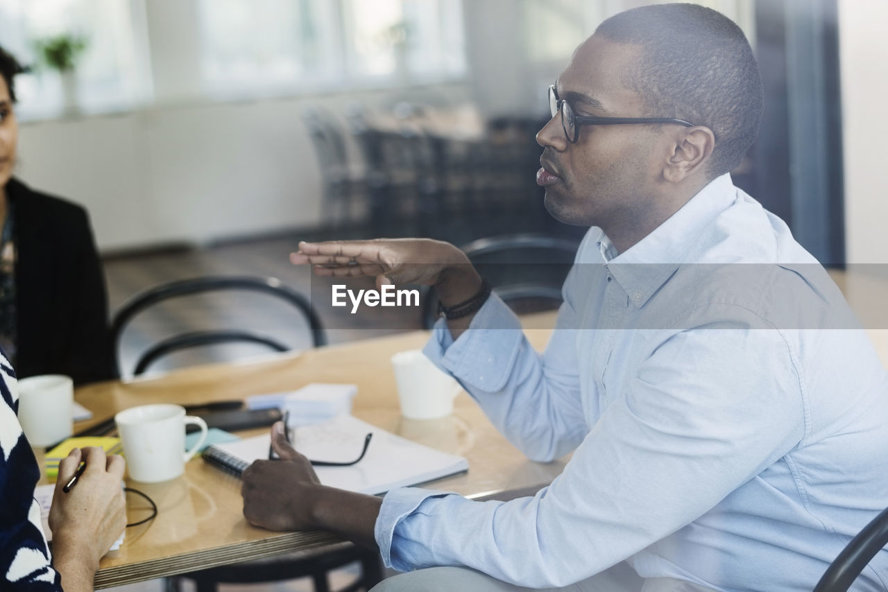 Businessman discussing with colleagues at board room