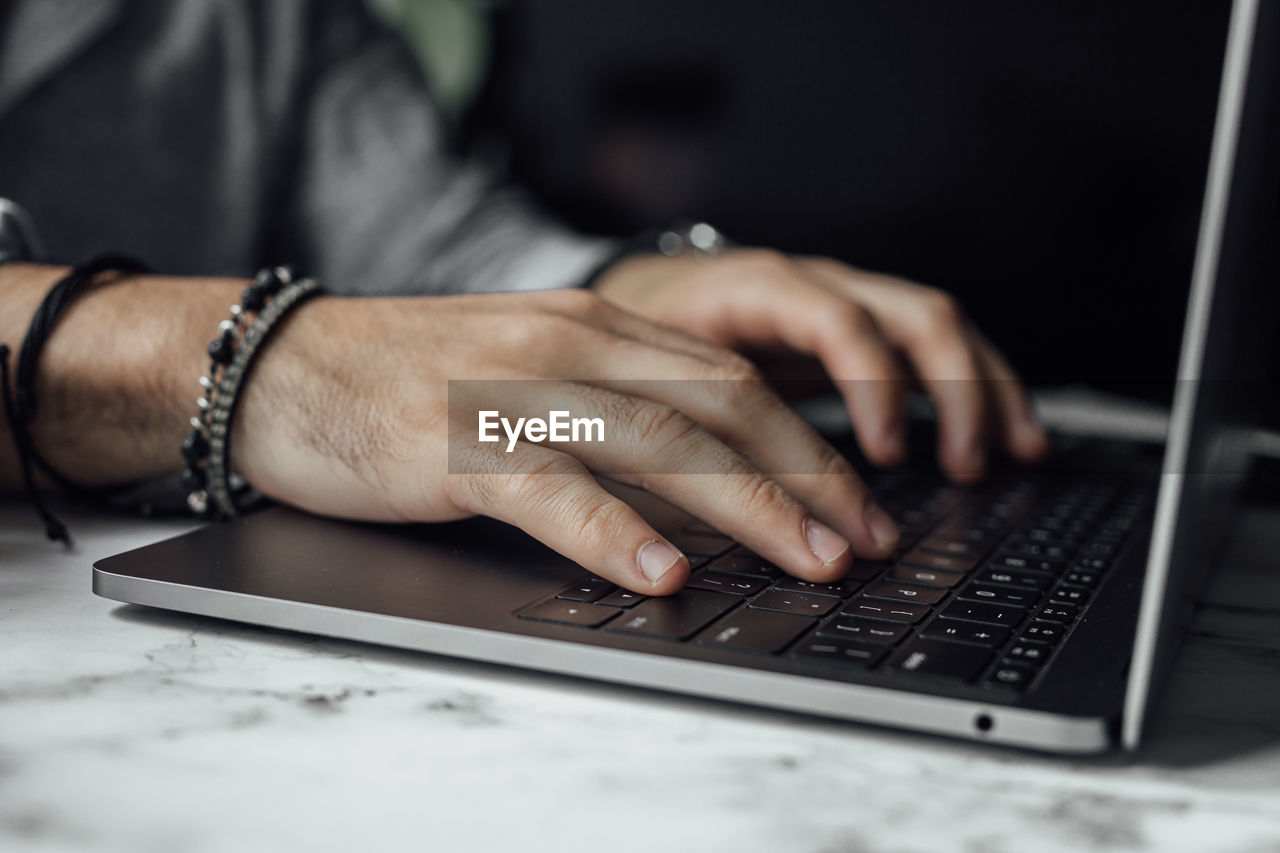 Midsection of man using laptop