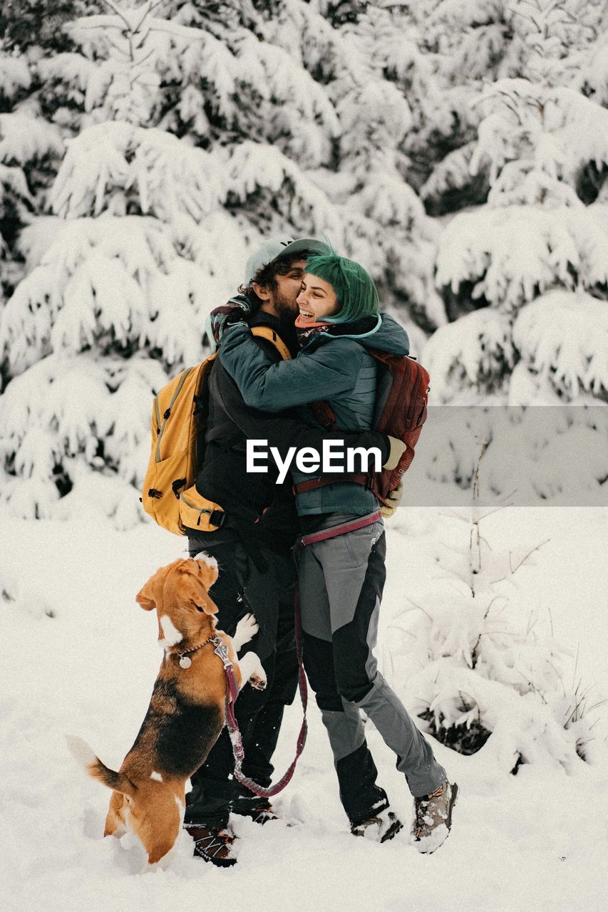 High angle view of a couple and a dog on snow during winter