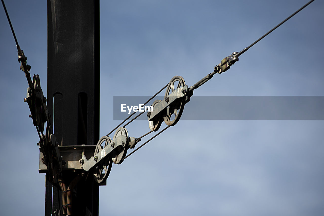 sky, blue, electricity, street light, lighting, no people, low angle view, mast, day, nature, communication, outdoors, light fixture, cable, overhead power line, sign, metal, architecture, technology, line, pole