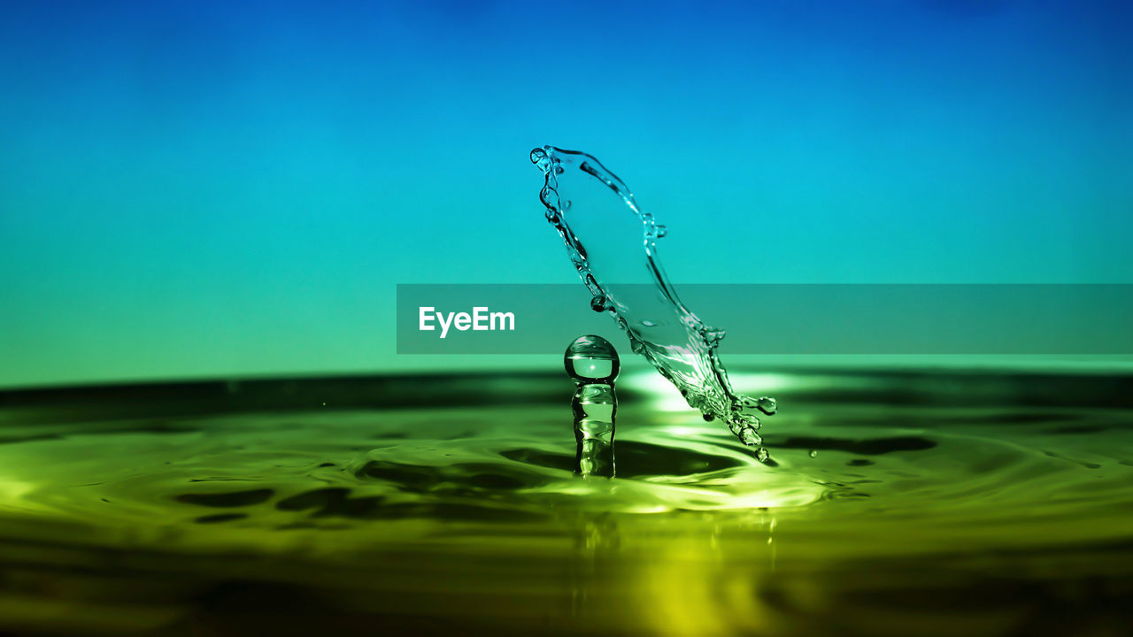 CLOSE-UP OF WATER SPLASHING ON BLUE BACKGROUND