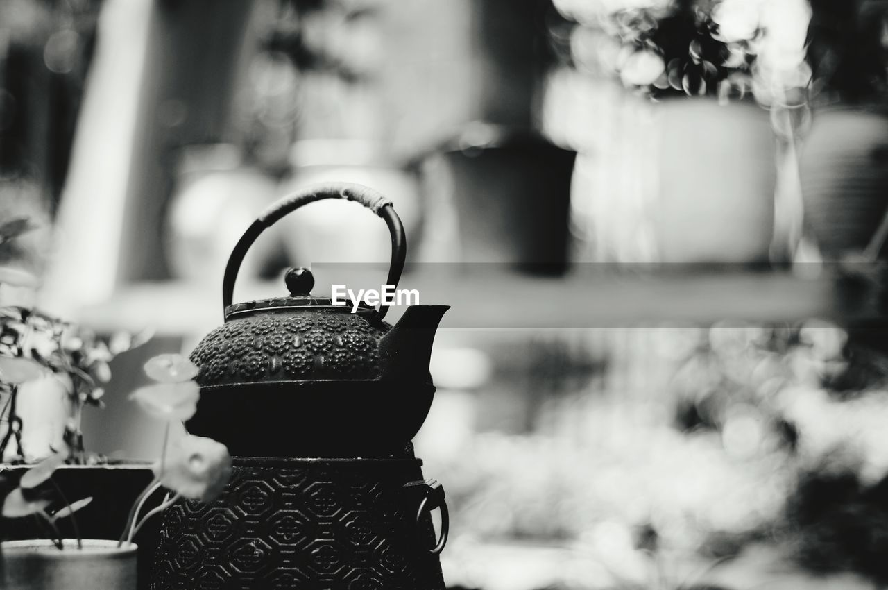 Close-up of teapot by flower pot