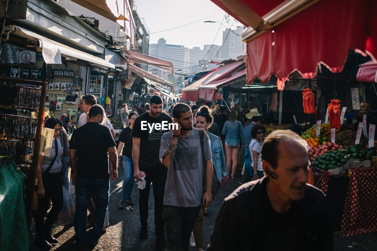 GROUP OF PEOPLE IN MARKET STALL