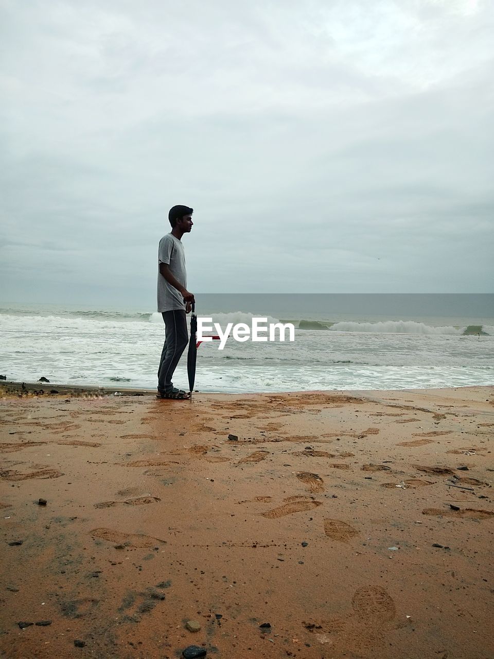 FULL LENGTH OF MAN STANDING ON BEACH