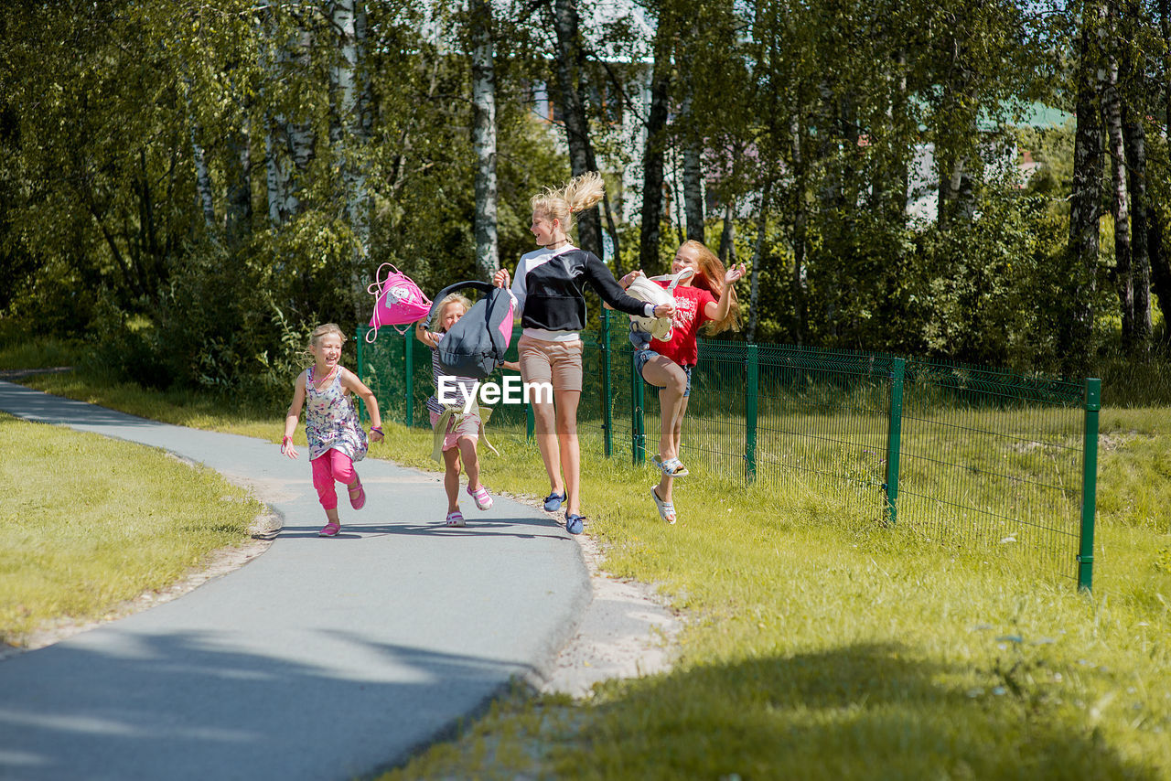 Siblings jumping over road in city