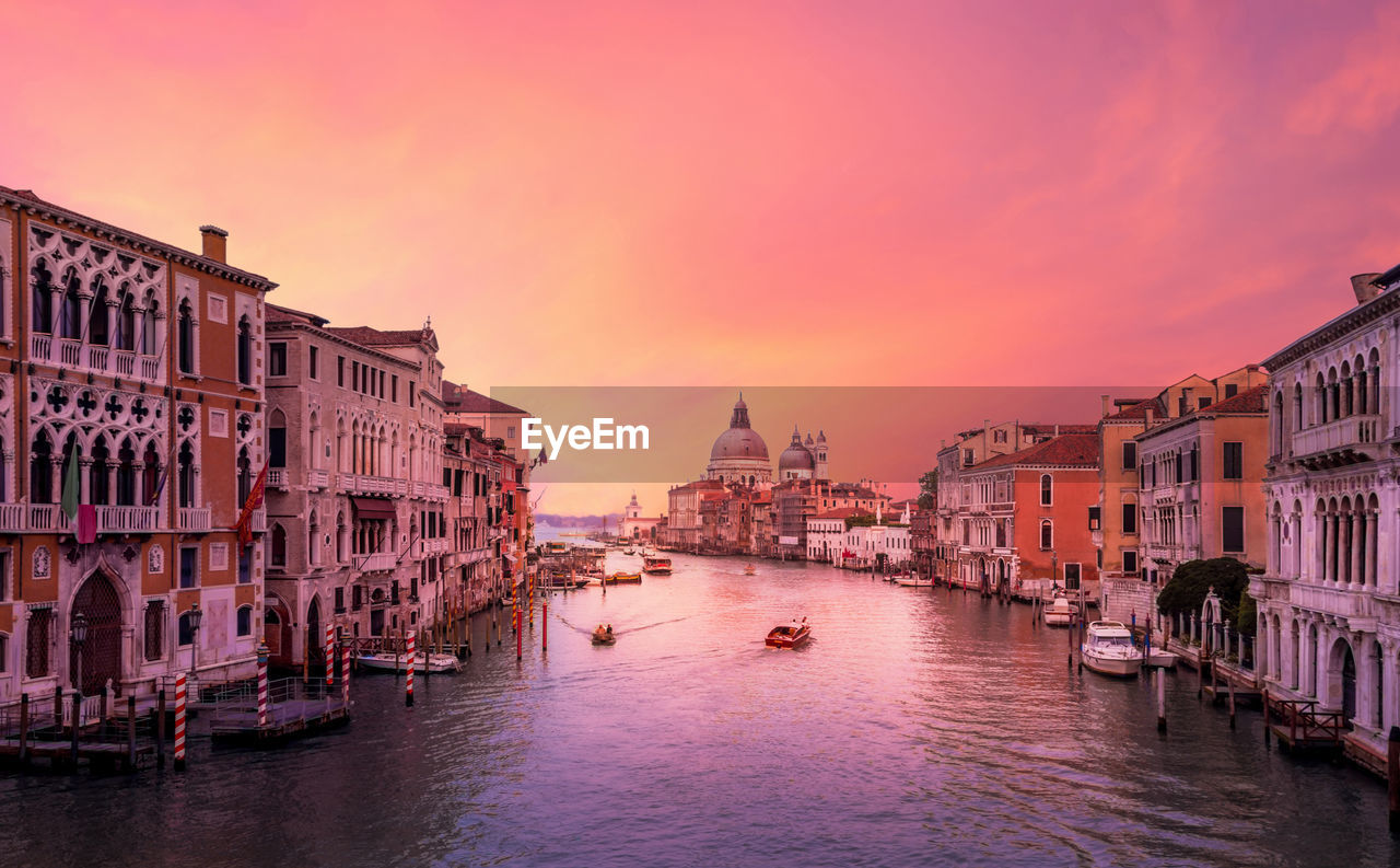 Grand canal amidst buildings in city during sunset