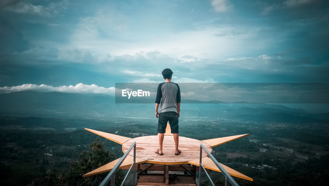 Rear view of man standing on observation point against sky