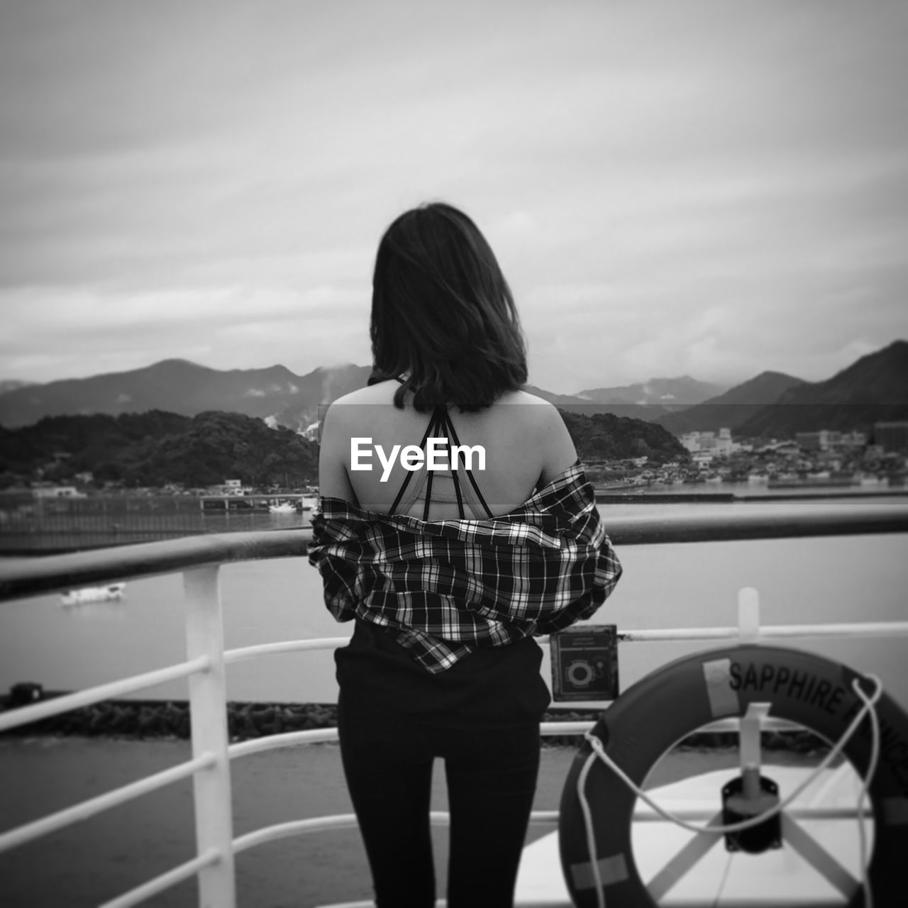 Rear view of woman standing on boat against sky