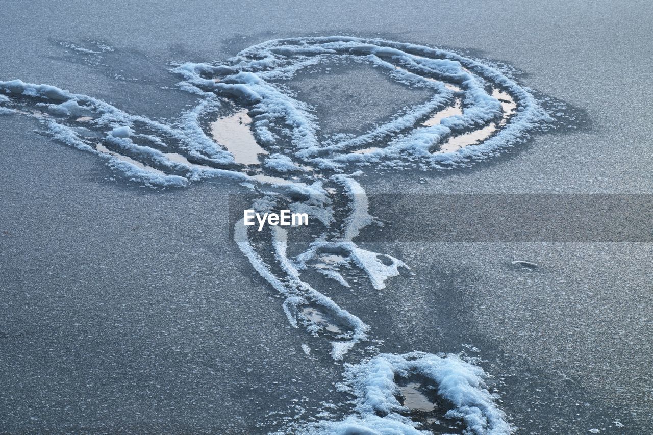 Snowy trails dressed in a blanket of snowy ice on lake. frozen water level in misty freeze winter