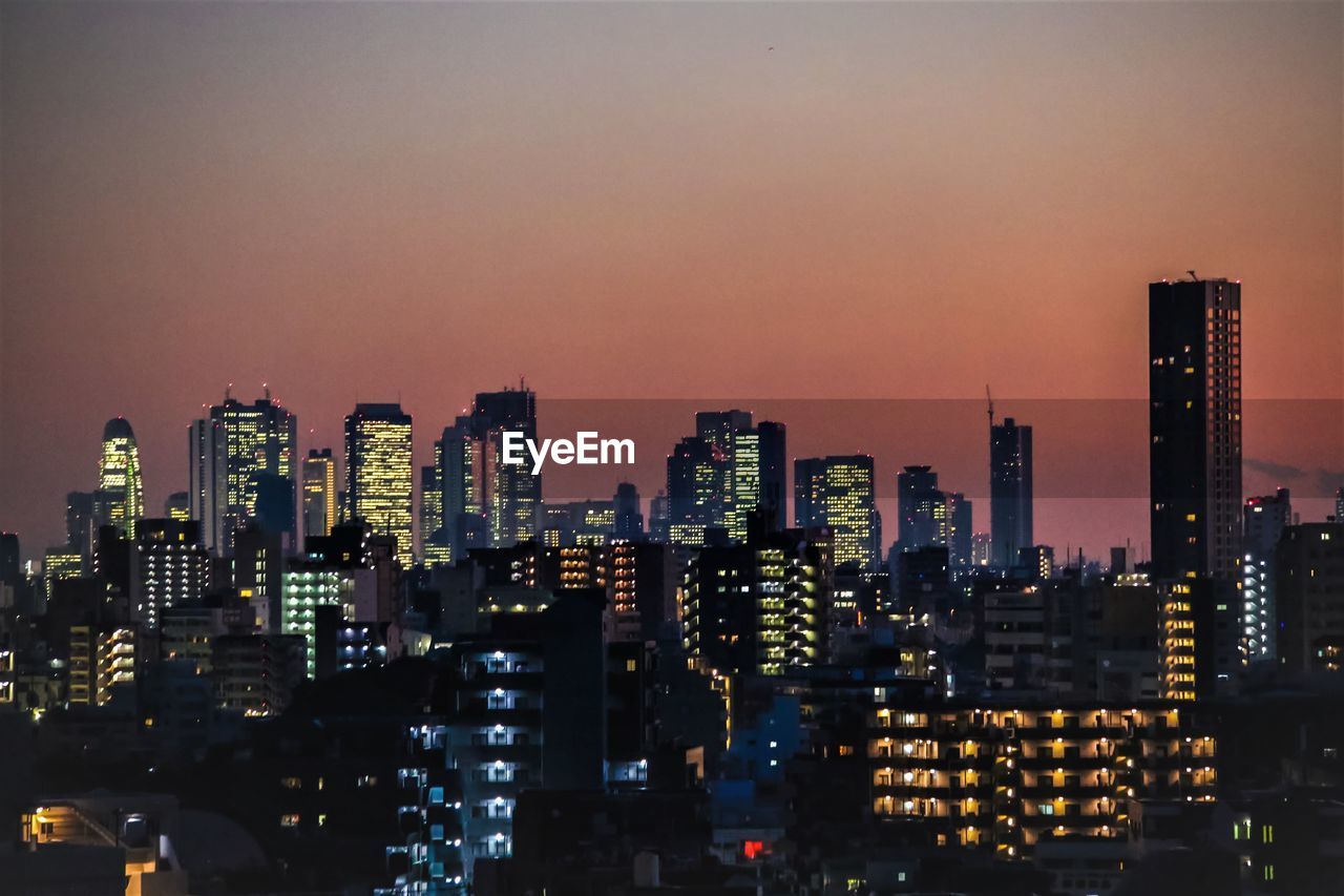 ILLUMINATED MODERN BUILDINGS IN CITY AT NIGHT