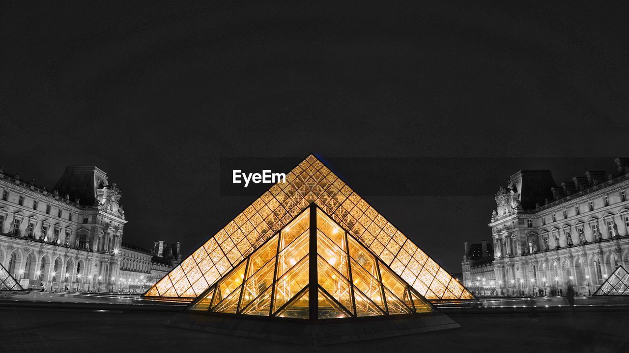 ILLUMINATED BUILDING IN CITY AGAINST SKY AT NIGHT