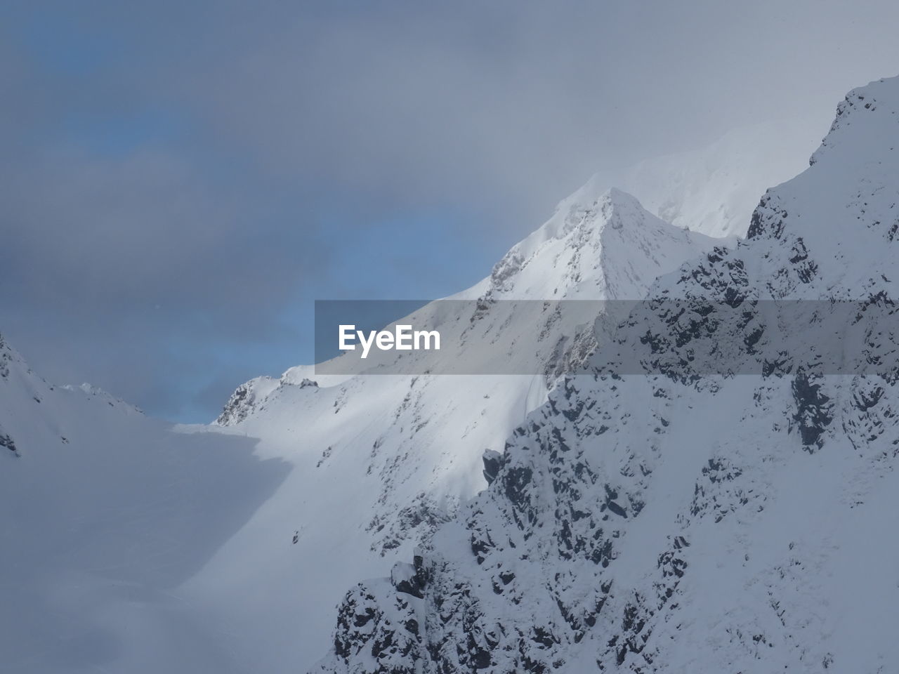 Scenic view of snow covered mountains against sky