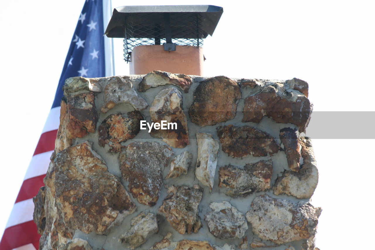 LOW ANGLE VIEW OF FLAG ON STONE
