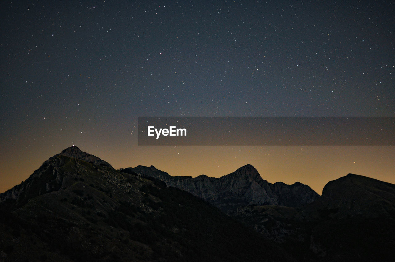 Scenic view of mountains against sky at night