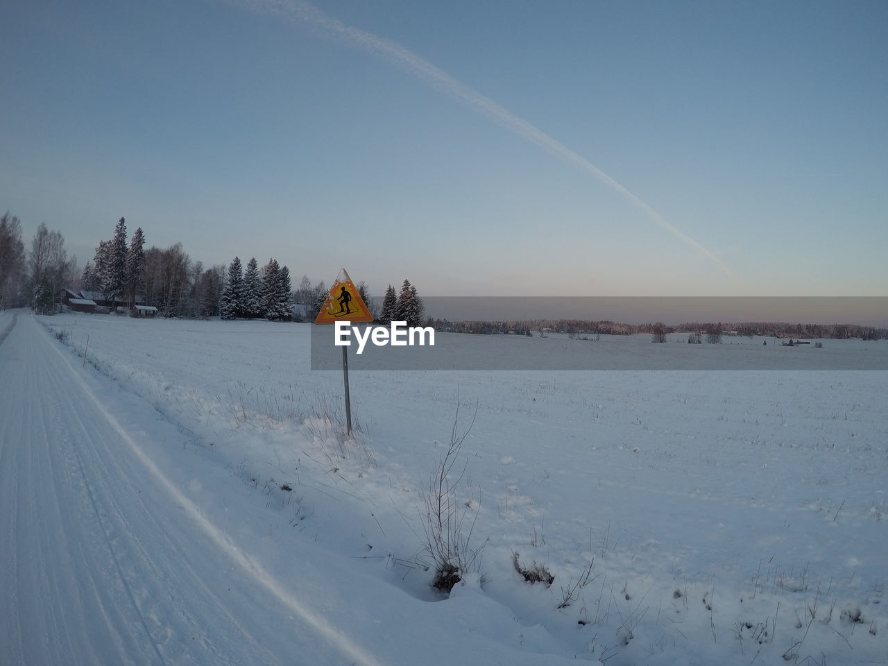 Scenic view of snow covered field against sky