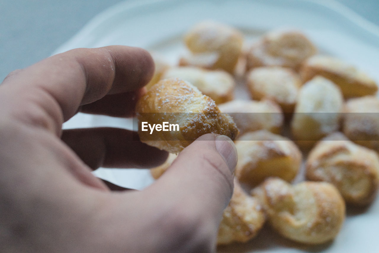 CLOSE-UP OF PERSON HAND HOLDING BREAD