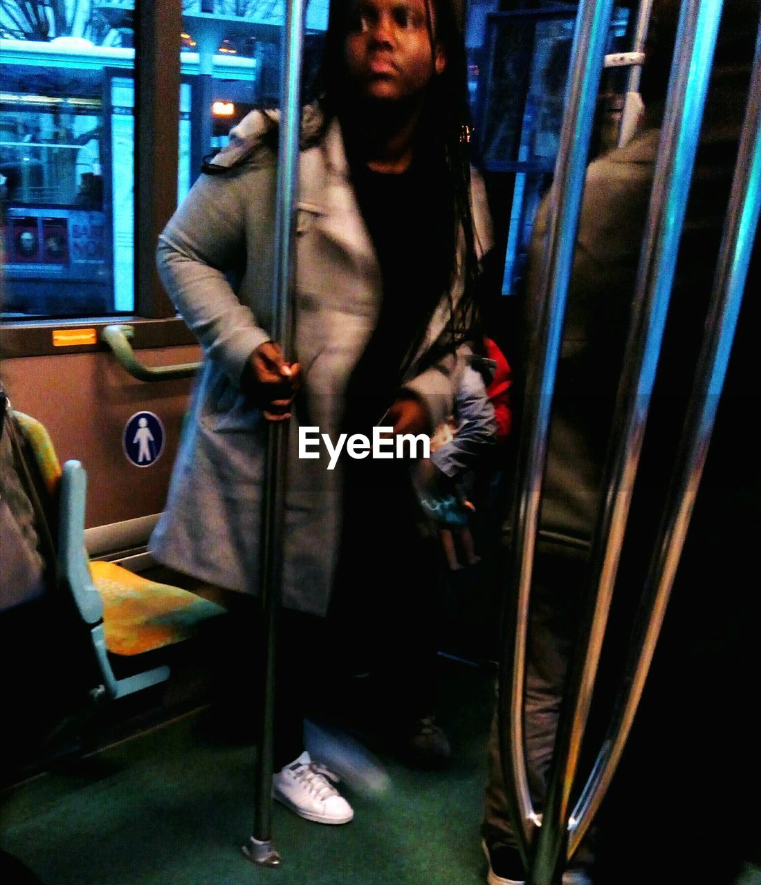 Blurred image of woman looking away while standing in metro train