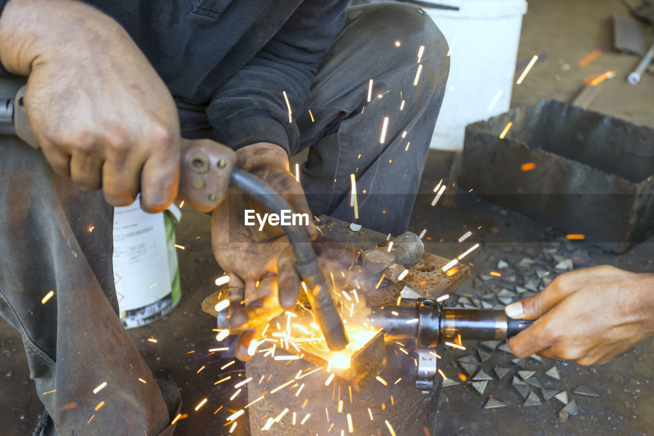 HIGH ANGLE VIEW OF MAN WORKING ON FIRE