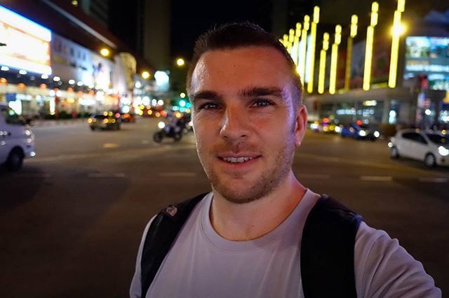 PORTRAIT OF YOUNG MAN STANDING AT NIGHT