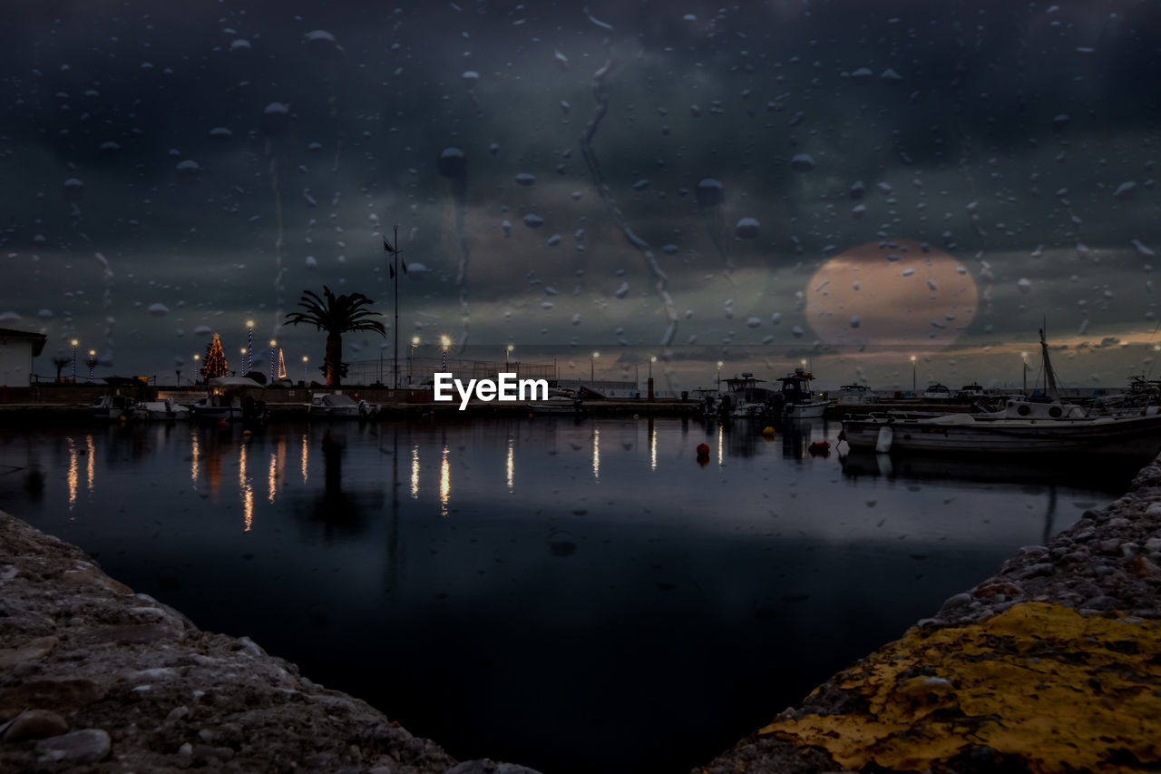 Scenic view of sea against sky at night with some raindrops