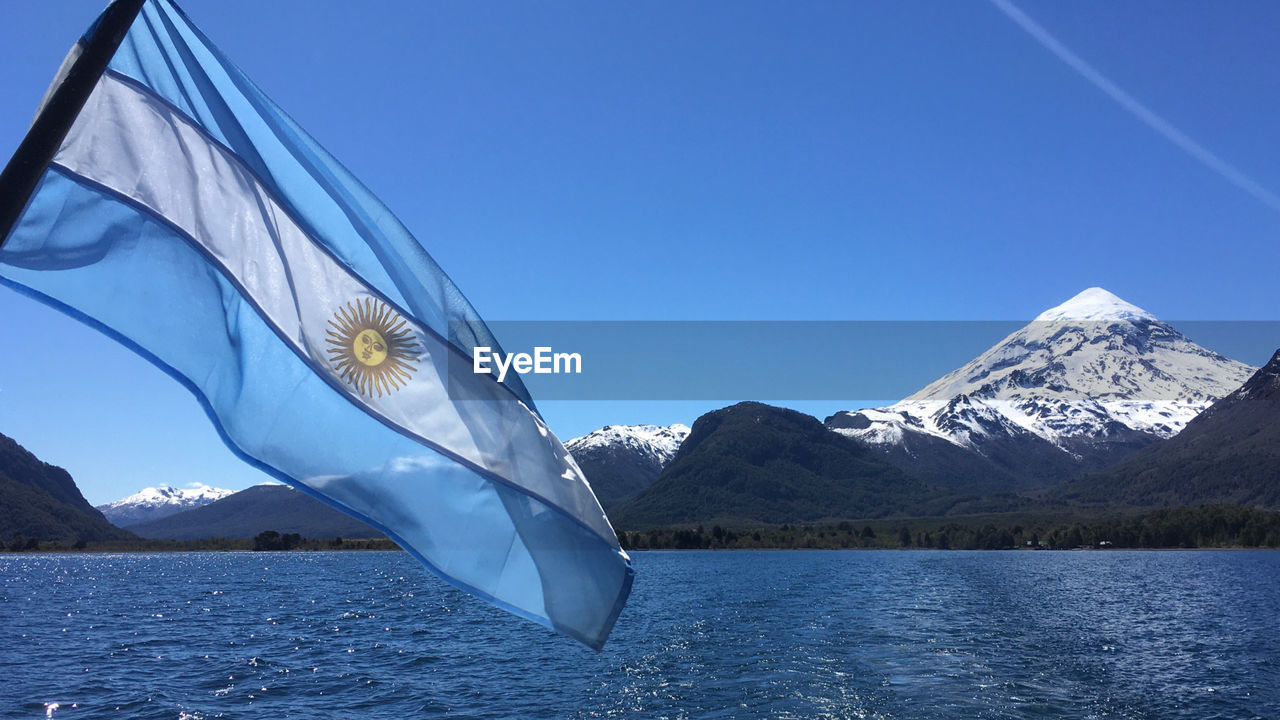 Huechalafquen lake with a view of the lanin volcano and the argentine flag