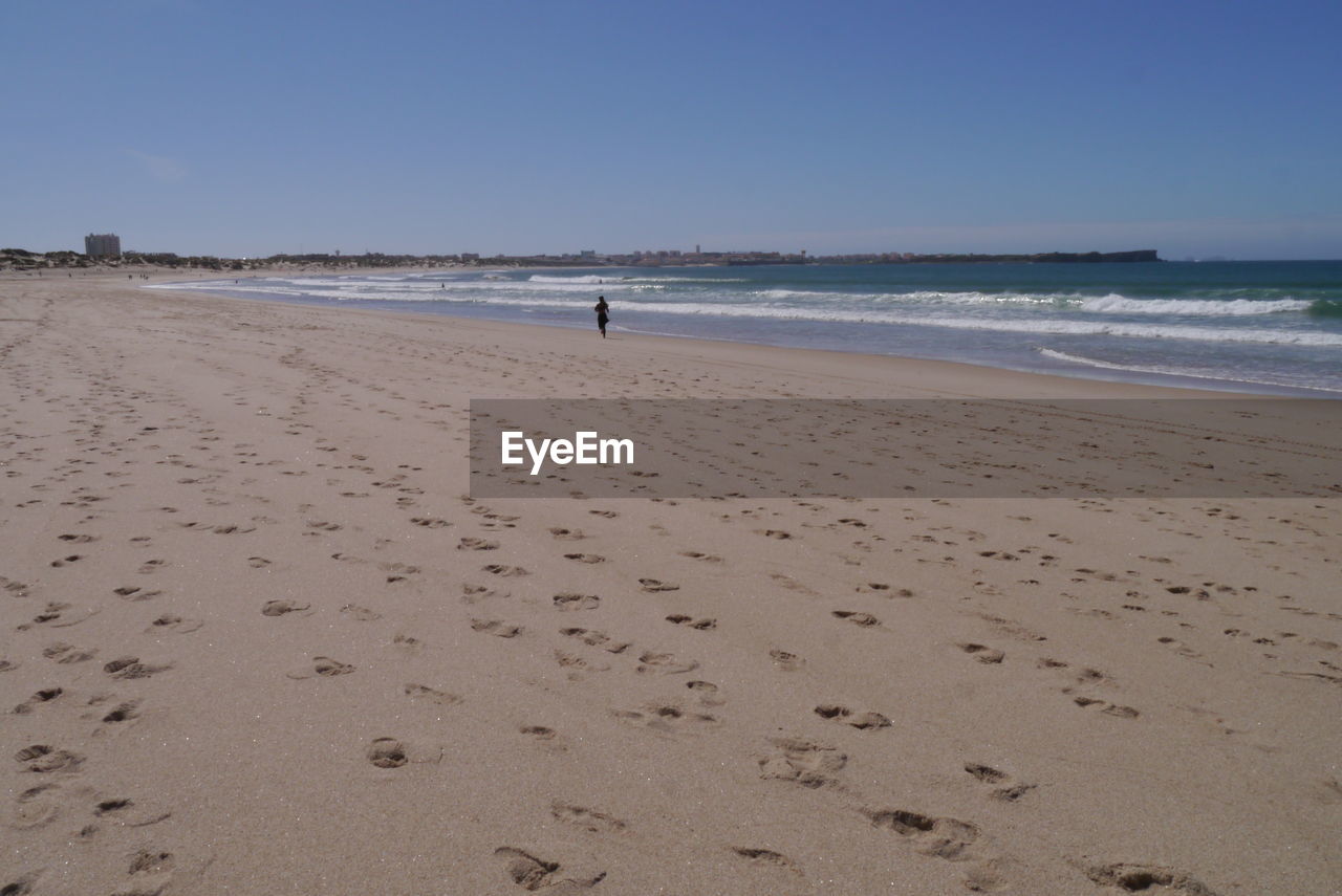 Scenic view of beach against blue sky