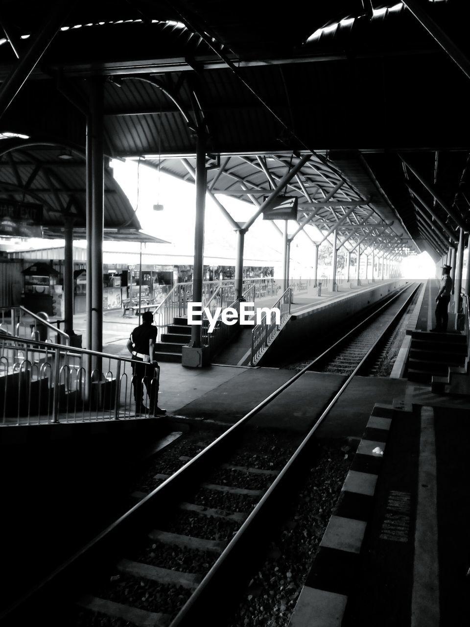 MAN WAITING AT RAILROAD STATION