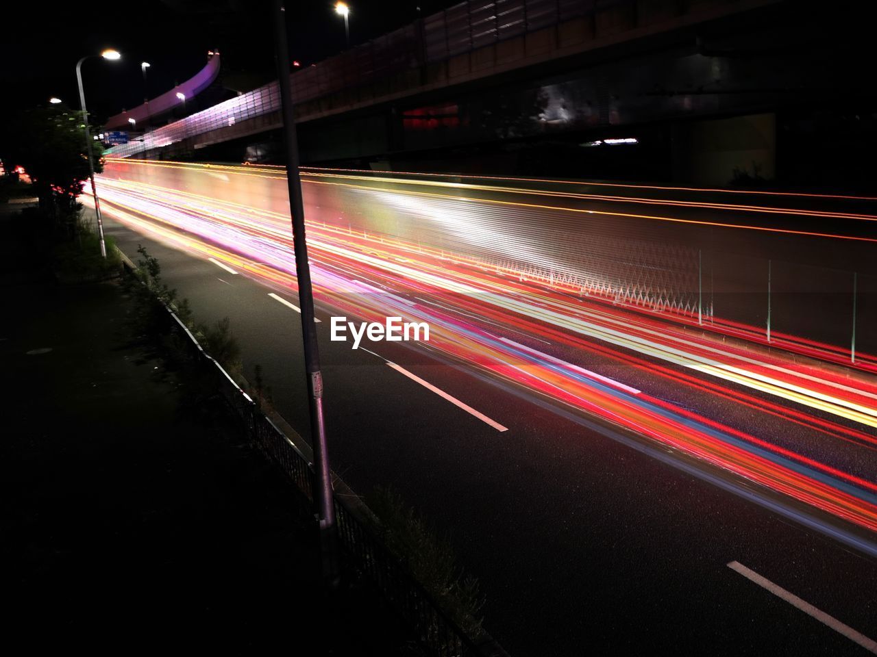 LIGHT TRAILS ON STREET AT NIGHT