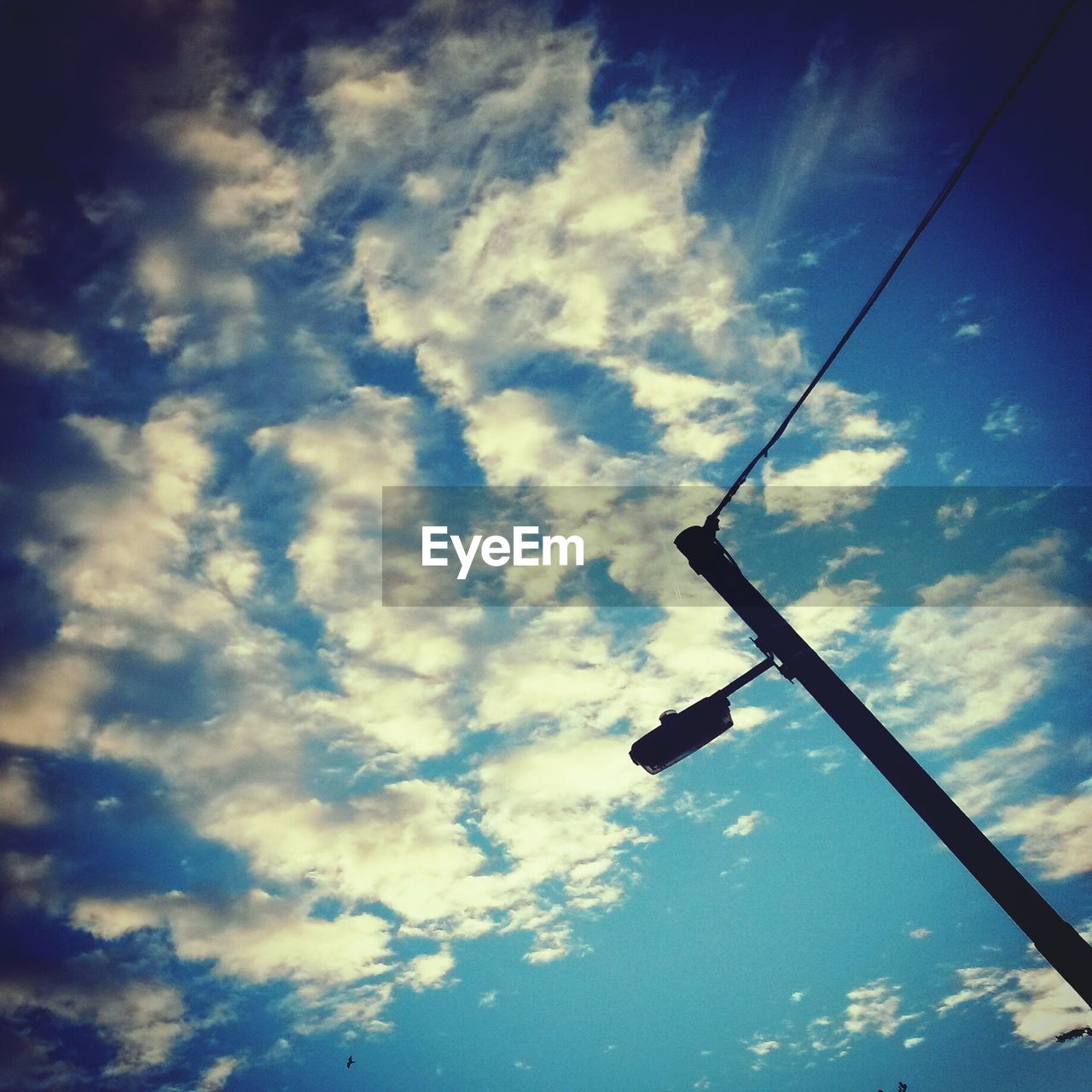 Low angle view of street light against cloudy sky