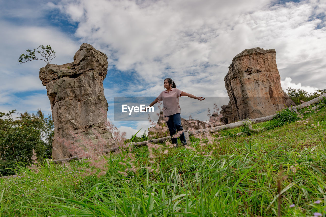 MAN STANDING ON ROCK IN FIELD