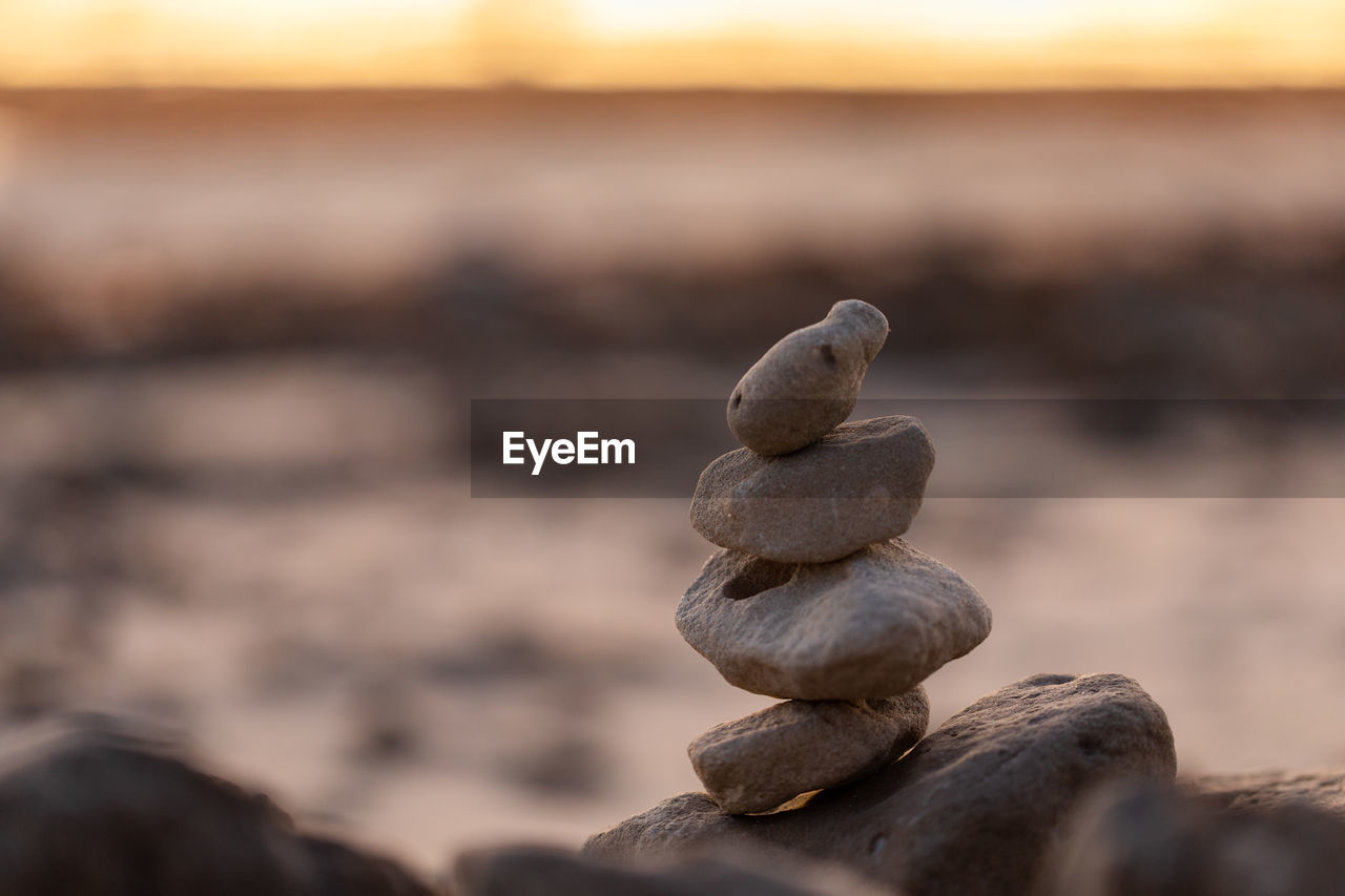 CLOSE-UP OF PEBBLES ON ROCK AT SEA SHORE