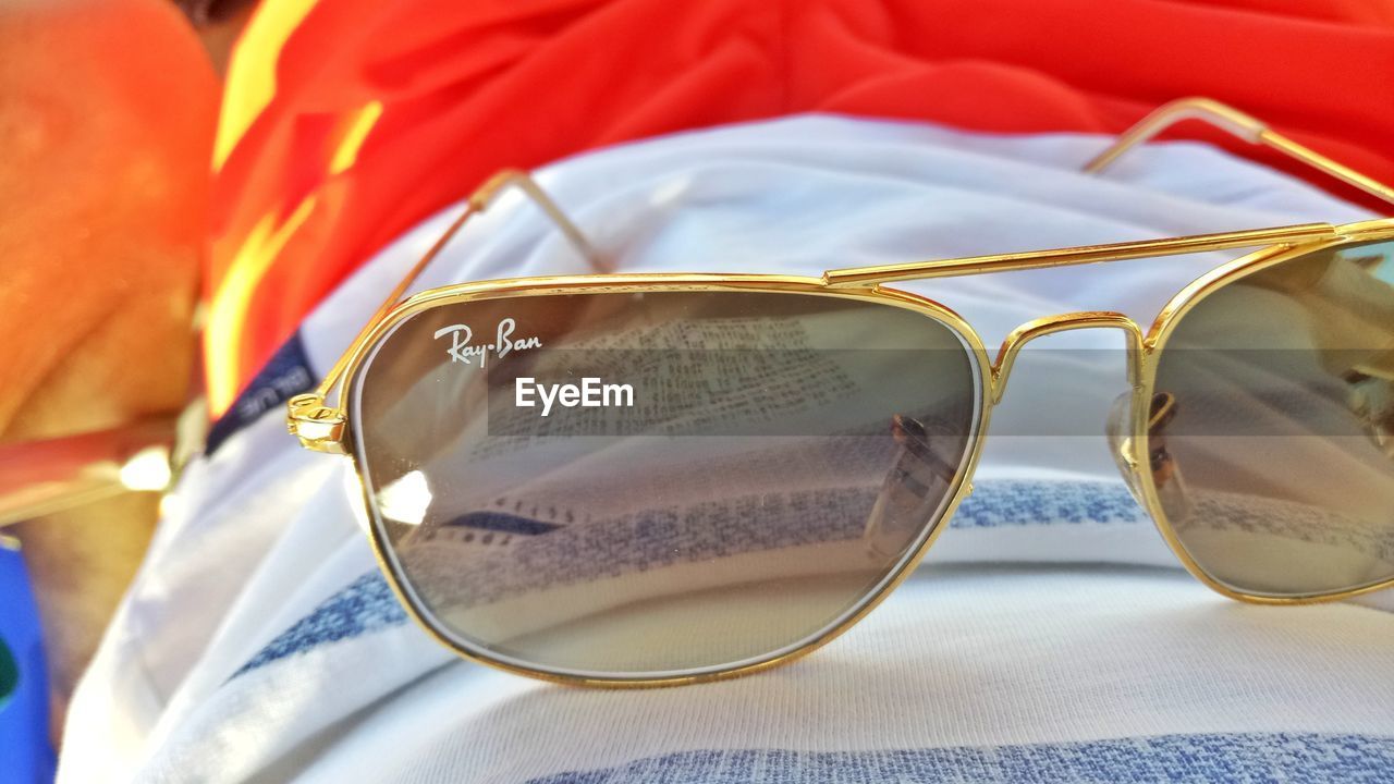 CLOSE-UP OF SUNGLASSES AND EYEGLASSES ON MIRROR