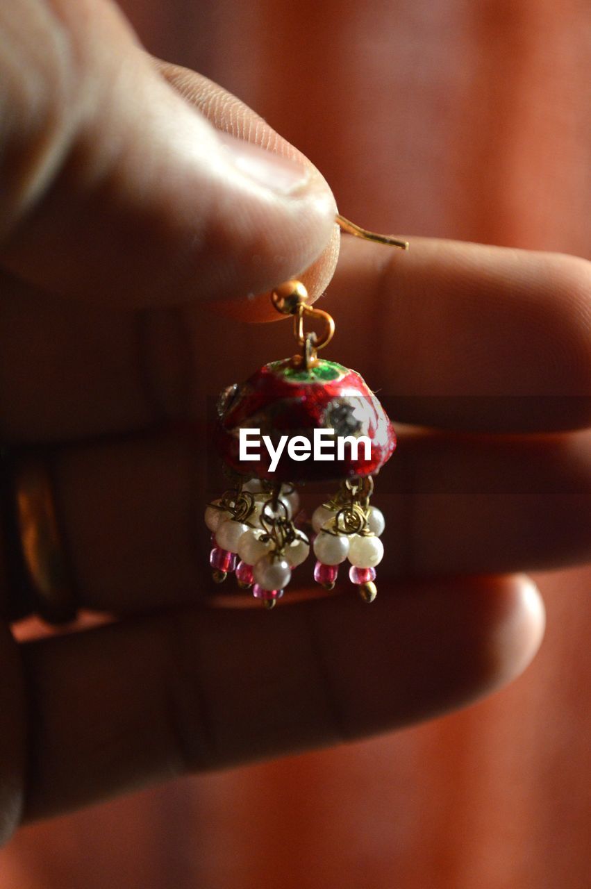 Close-up of hand holding earring
