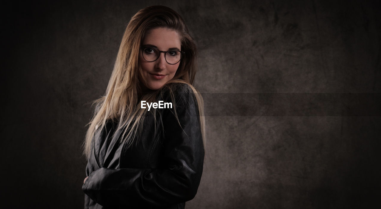 portrait of young woman standing against wall