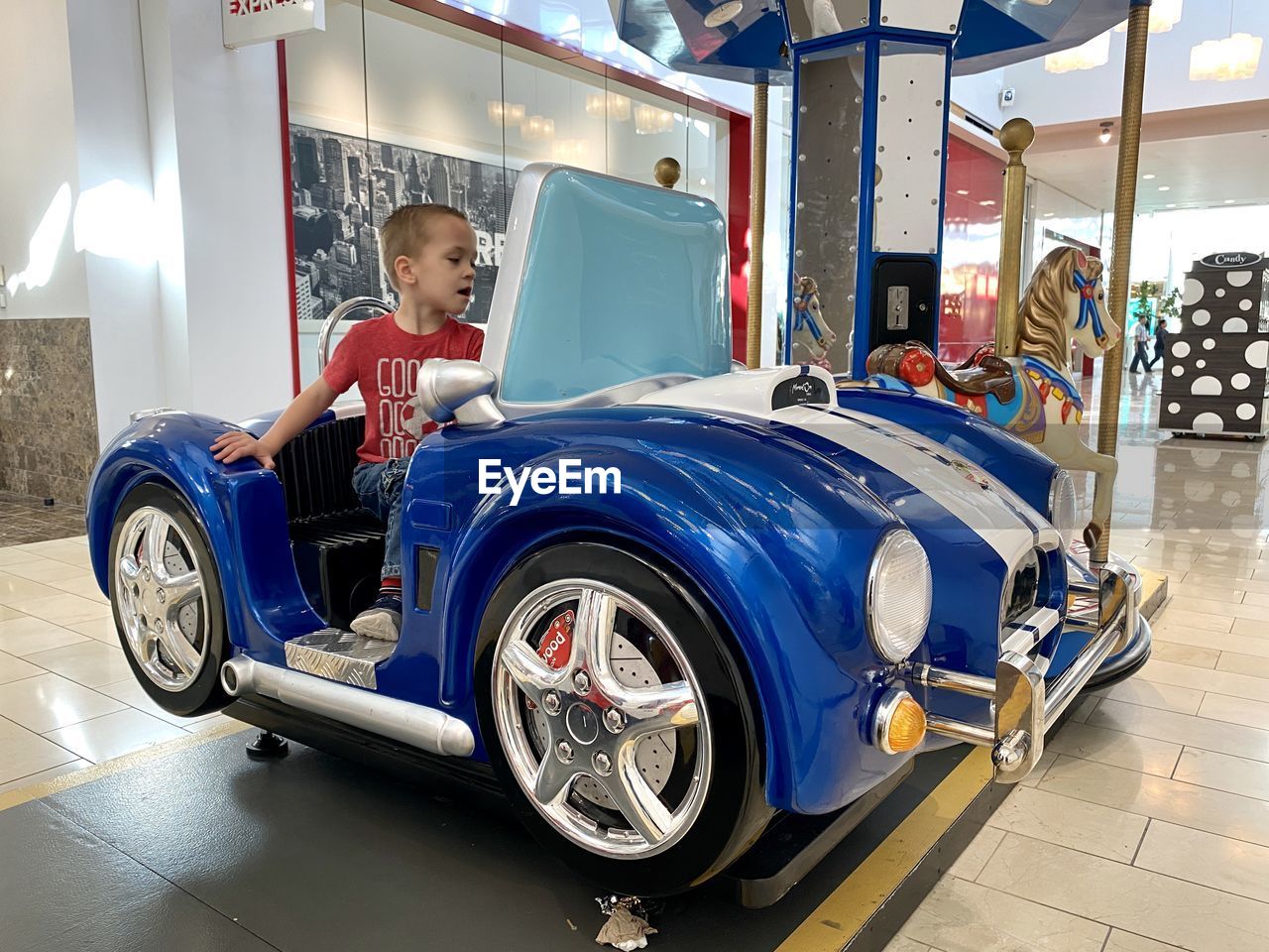 HIGH ANGLE VIEW OF BOY ON CAR