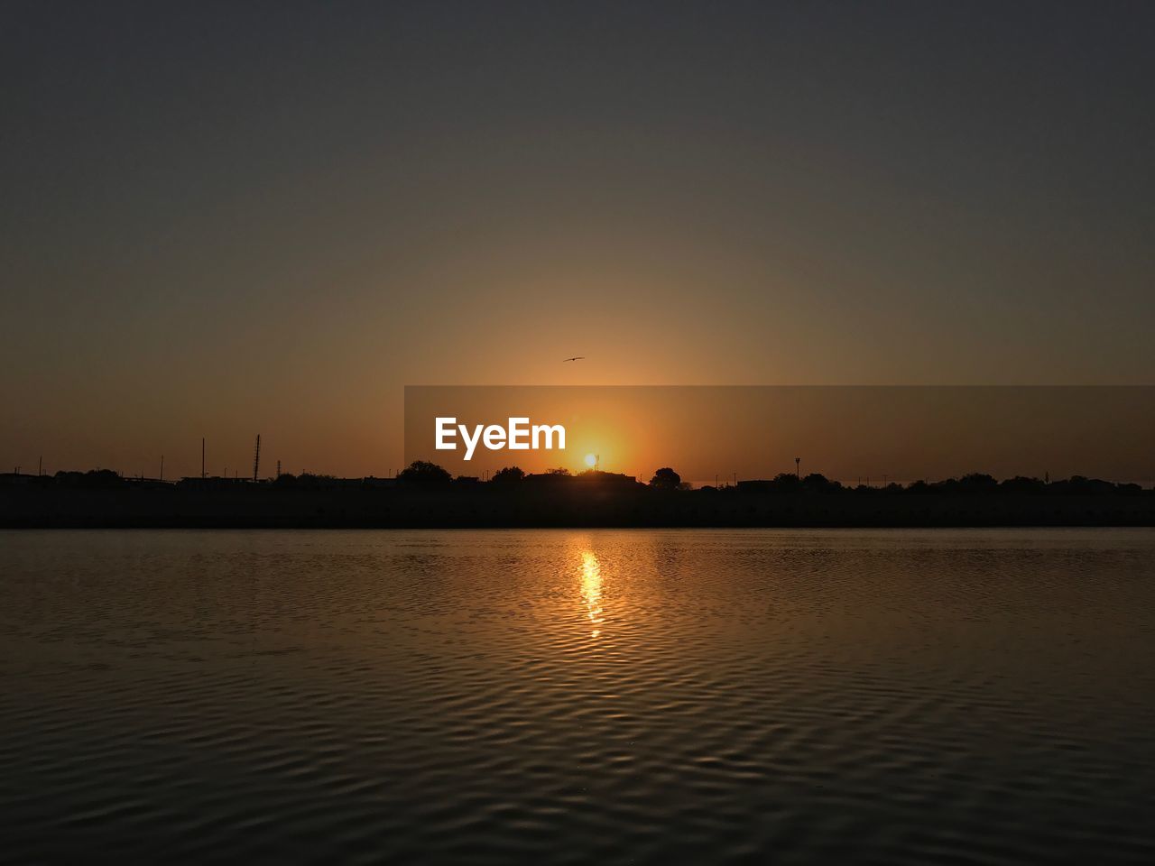 VIEW OF SUN SHINING OVER WATER