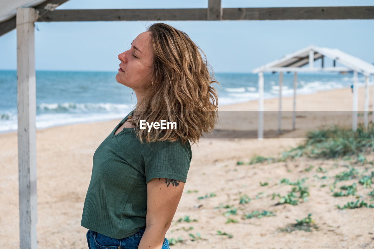 Woman with eyes closed standing at beach