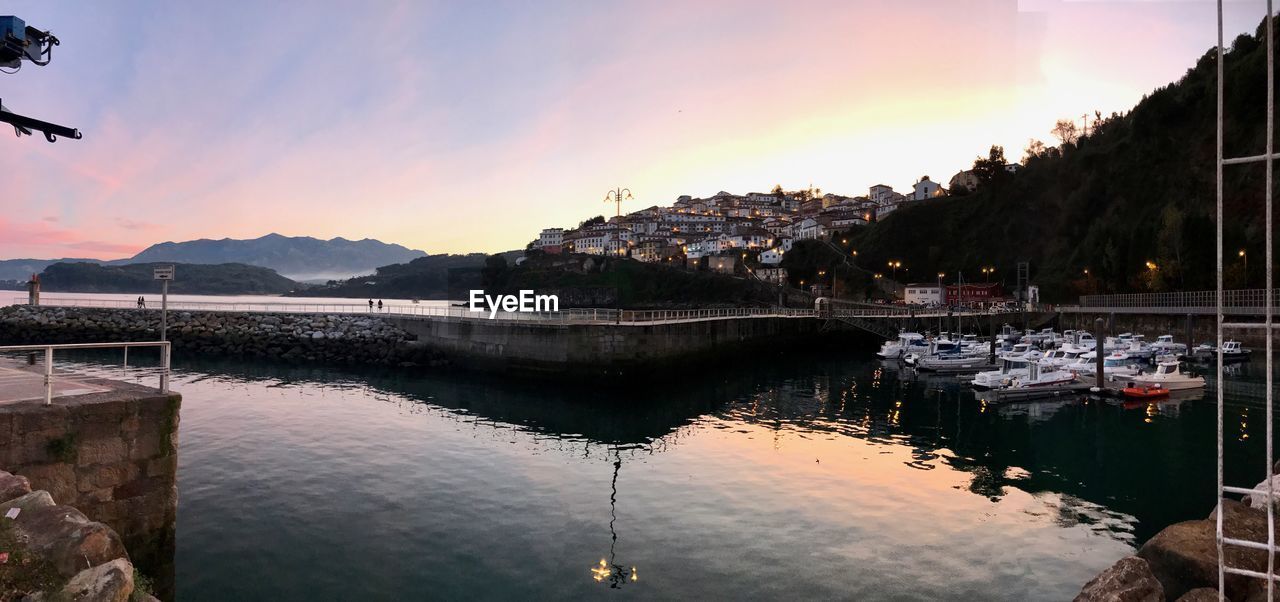 SCENIC VIEW OF LAKE BY MOUNTAINS AGAINST SKY DURING SUNSET