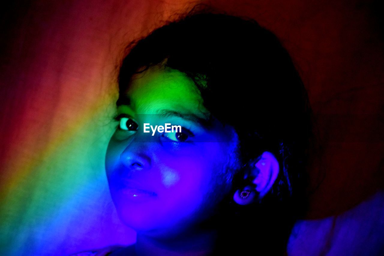 CLOSE-UP PORTRAIT OF A BOY IN ILLUMINATED LIGHT