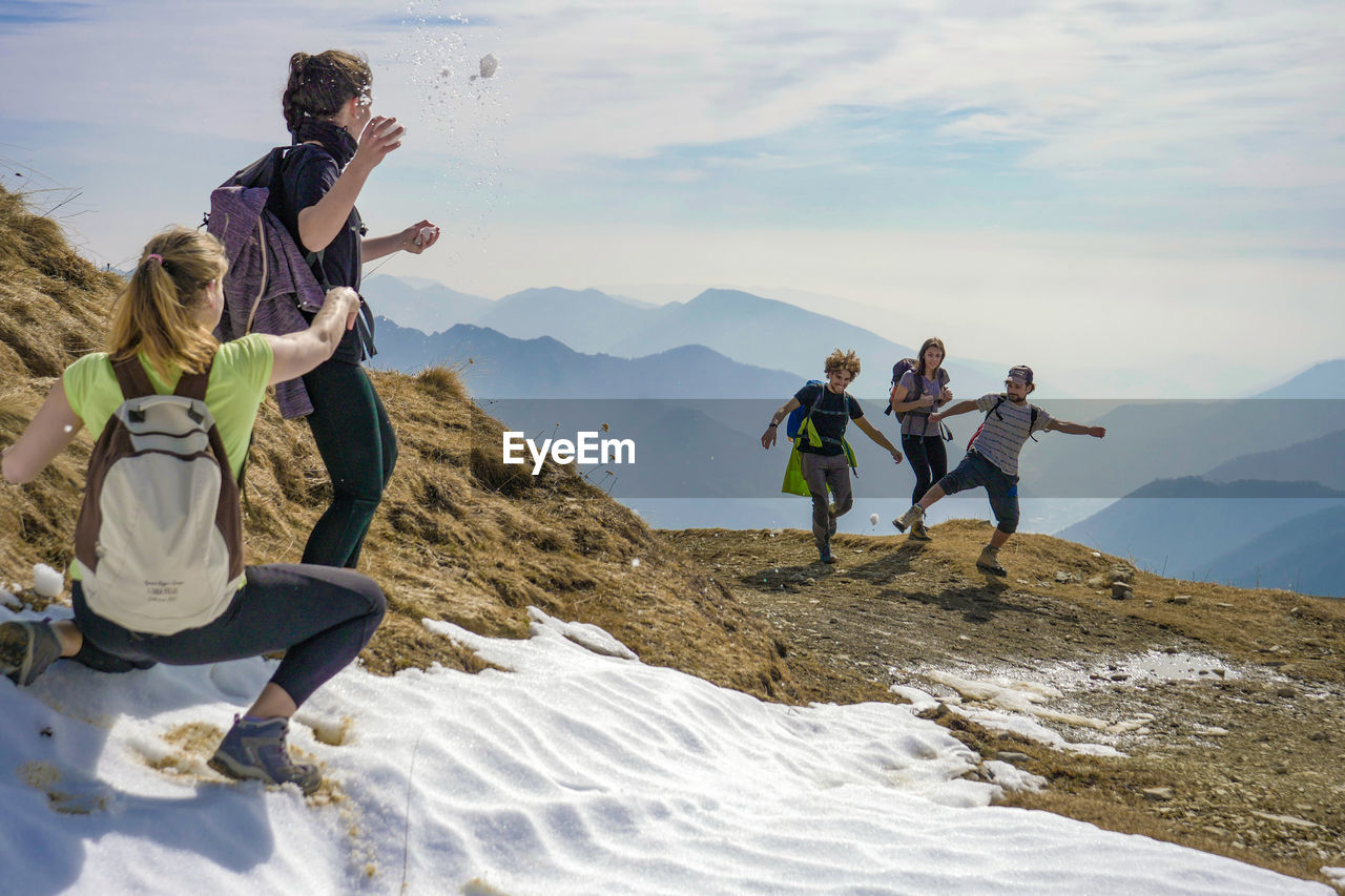 PEOPLE ON MOUNTAIN AGAINST SKY